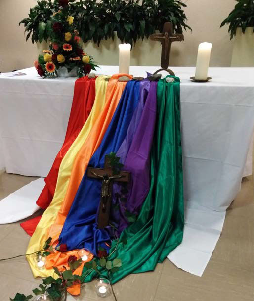 Gedenk-Schrein in der Kirche mit Regenbogentüchern, Kreuz und Kerzen